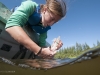 Blaize Denfeld collects a water sample.