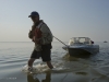 Dr. Max Holmes pulls his small boat through the shallow water near the mouth of the Kolyma.